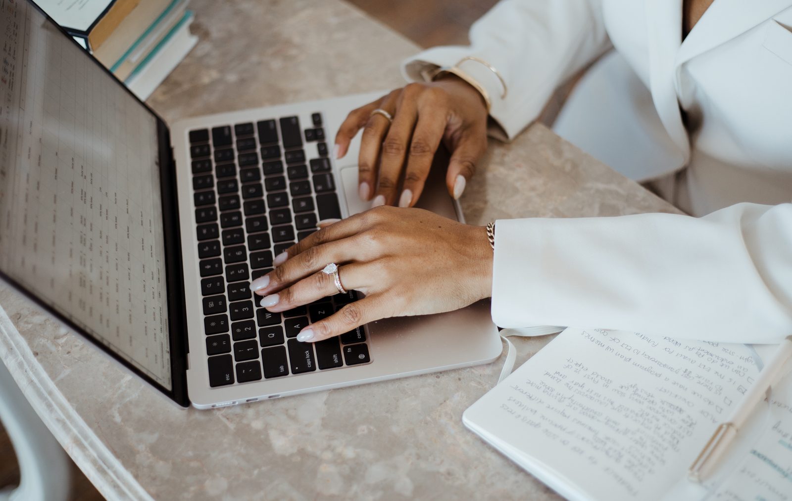 Leya working at her laptop with notebook and notes